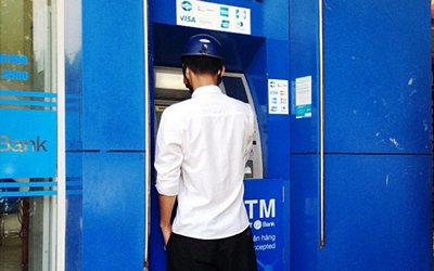 Một người đàn ông rút sạch tiền từ thẻ ATM nhặt được - Ảnh: Doãn Hòa