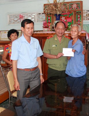 Thiếu tướng Lê Văn Út- Thường vụ Tỉnh ủy, Giám đốc Công an tỉnh tặng quà cho các gia đình chính sách.