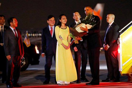 Tổng thống Obama nhận hoa từ Trần Mỹ Linh ngay khi bước xuống khỏi chuyên cơ. Ảnh: Reuters.