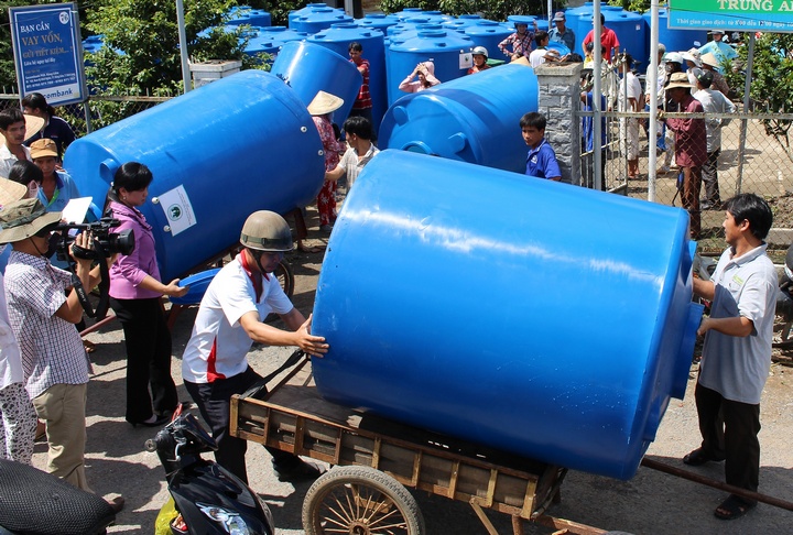 Các hộ dân phấn khởi nhận bồn chứa nước đem về nhà.