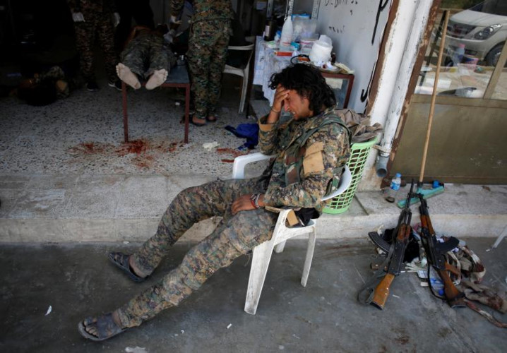 Một tay súng của phe đối lập SDF hét lên vì đau đớn trong khi đồng đội của anh đang được điều trị ở phía trong.