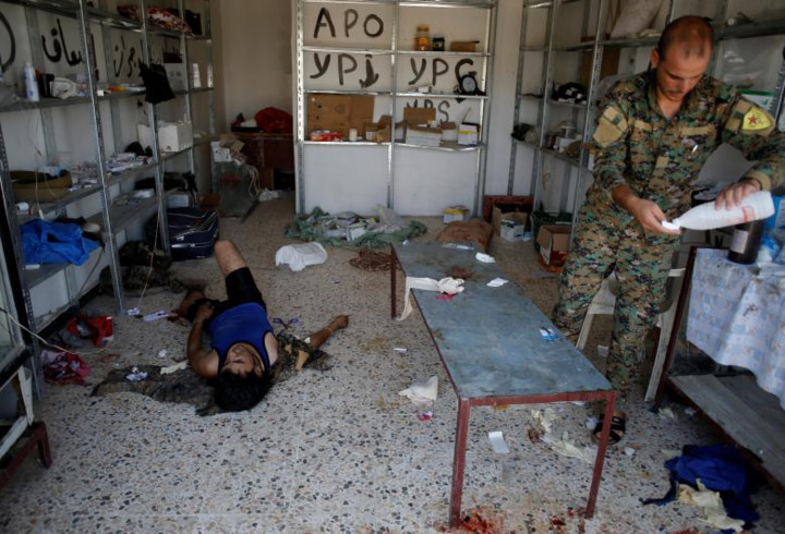 Một chiến binh của lực lượng SDF nằm lăn ra sàn nhà sau khi vừa được điều trị xong.