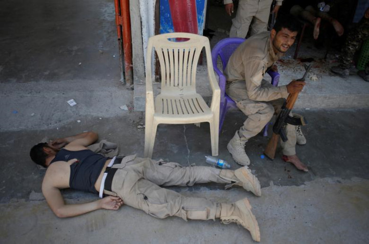 Một chiến binh trúng đạn pháo của IS nằm sấp mặt xuống đường ngay bên ngoài bệnh viện dã chiến.
