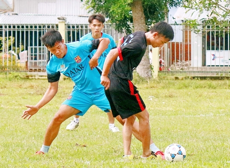 Pha tranh bóng của đội Bình Phước (áo xanh) tại môn bóng đá nam hội thao CNVC-LĐ huyện Mang Thít.