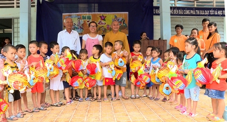 Đại đức Thích Tịnh Hòa – Trụ trì chùa Sơn An  cùng chính quyền địa phương trao quà cho các em học sinh   