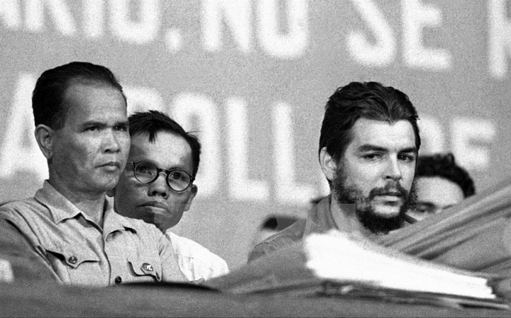 Che Guevara và Anh hùng Núp (nhân dân Cuba gọi ông là Anh hùng miền núi) trong một cuộc míttinh đoàn kết với Việt Nam tại La Habana năm 1964 (người ngồi giữa là nhà báo TTXVN Vũ Văn Âu, làm phiên dịch cho Anh hùng Núp trong chuyến thăm Cuba). (Nguồn: Prensa Latina/TTXVN)