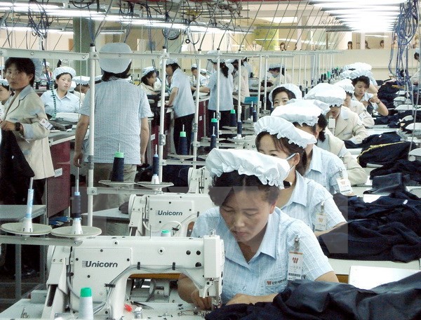 Công nhân làm việc tại một nhà máy dệt may của Triều Tiên trong khu công nghiệp Kaesong ngày 22/5/2007. (Nguồn: AFP/TTXVN)