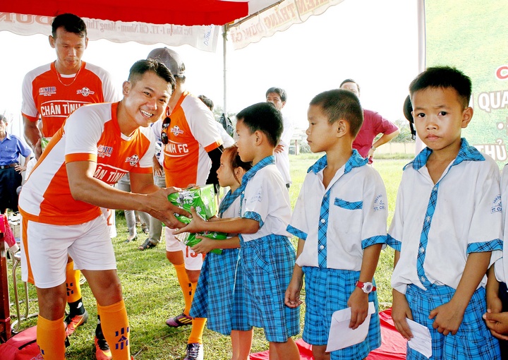 Ca sĩ Vân Quang Long trao quà cho học sinh tại huyện Mang Thít.