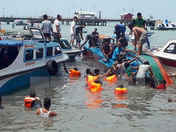 Lực lượng cứu hộ tìm kiếm nạn nhân sau vụ lật tàu ngày 25/7. (Nguồn: EPA/TTXVN)
