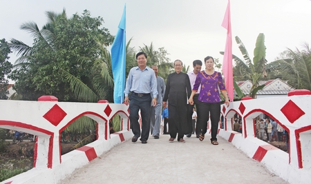 Ông Lê Văn Phúc- Phó Bí thư Huyện ủy, Chủ tịch UBND huyện (bìa trái) cùng người dân đi qua cầu ngọn Tầm Vu tại lễ khánh thành. 