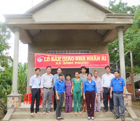 Gia đình anh Huỳnh Chí Tâm chụp ảnh lưu niệm với lãnh đạo địa phương và đoàn viên thanh niên trong ngày bàn giao nhà mới.