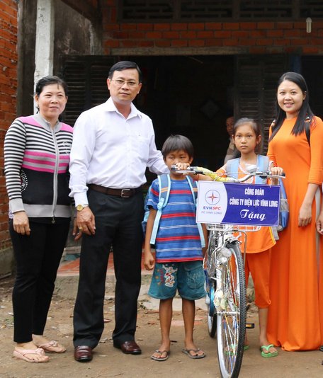  Ông Huỳnh Vĩnh Phúc- Chánh Văn phòng Công ty Điện lực Vĩnh Long- tặng tiền, cặp và xe đạp cho 2 bé có mẹ bị bệnh hiểm nghèo ở xã Đông Thành (TX Bình Minh).