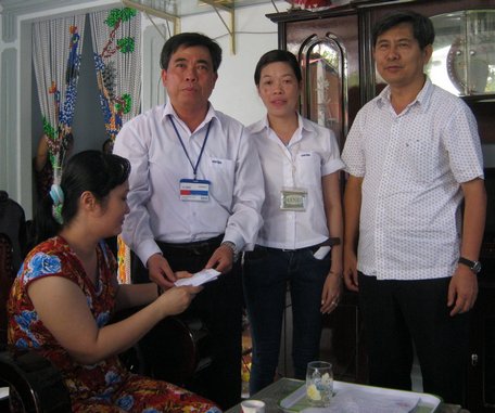 Ông Nguyễn Minh Tuệ (phải)- Giám đốc Công ty CP May Vĩnh Tiến (bìa phải) hỗ trợ tiền cho một công nhân bị bệnh ung thư.