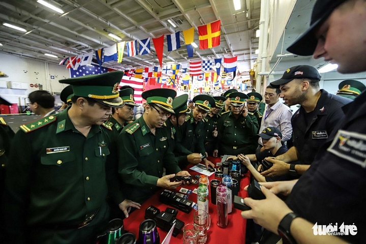 Các sĩ quan Bộ đội biên phòng Việt Nam tranh thủ mua đồ tại quầy hàng lưu niệm trên tàu sân bay - Ảnh: NGUYỄN KHÁNH