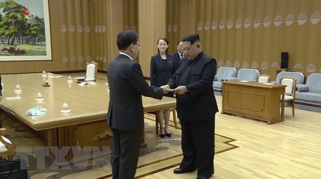 Nhà lãnh đạo Triều Tiên Kim Jong-un (phải) nhận thư của Tổng thống Hàn Quốc Moon Jae-in được ông Chung Eui-yong (trái) chuyển tới Bình Nhưỡng ngày 5/3. (Nguồn: YONHAP/TTXVN)