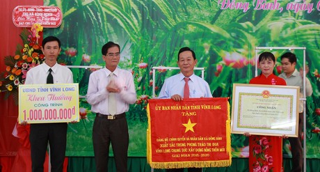 Ông Lê Quang Trung- Ủy viên Thường vụ Tỉnh ủy, Phó Chủ tịch Thường trực UBND tỉnh trao bằng công nhận đạt chuẩn nông thôn mới và khen thưởng công trình phúc lợi trị giá 1 tỷ đồng cho xã Đông Bình.