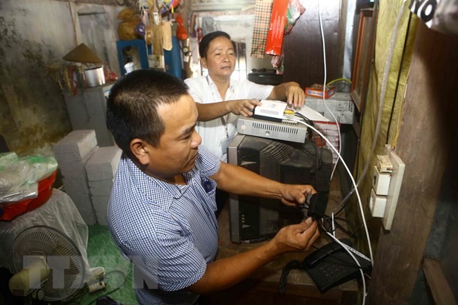 Lắp đặt đầu thu truyền hình số mặt đất cho hộ gia đình ở Hà Nội. (Ảnh: Minh Quyết/TTXVN)