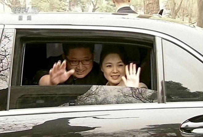 Ông Kim Jong-un cùng phu nhân, bà Ri Sol Ju mỉm cười thân thiện với các phóng viên tại Bắc Kinh. Ảnh: CCTV