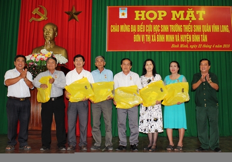 Ông Hoàng Thanh Sơn- Trưởng Ban liên lạc Thiếu sinh quân Quân khu 9 (trái) và ông Phan Chí Khinh- Trưởng Ban liên lạc Thiếu sinh quân tỉnh Vĩnh Long trao tặng kỷ niệm chương và quà cho các cựu học sinh trường.