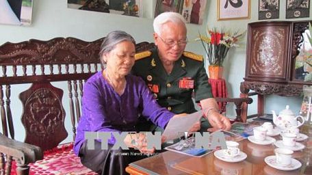 Đại tá Trịnh Xuân Ứng xem lại những kỷ vật xưa. Ảnh: Hải Yến/TTXVN