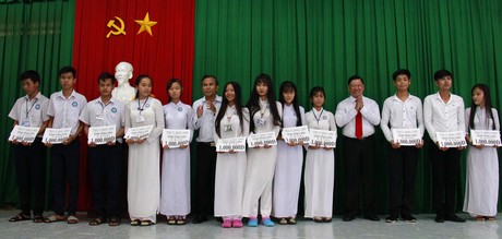 Bí thư Tỉnh ủy-Trần Văn Rón (thứ 4, bên phải) trao học bổng cho các em học sinh vượt khó học tốt.