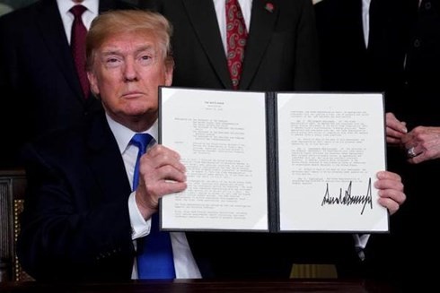 Tổng thống Donald Trump cầm văn bản ghi nhớ về việc áp thuế hàng hóa của Trung Quốc tại Nhà Trắng hôm 22/3. (Ảnh: Reuters).