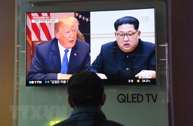 Người dân theo dõi truyền hình đưa tin về Tổng thống Mỹ Donald Trump (trái) và Nhà lãnh đạo Triều Tiên Kim Jong-un, tại nhà ga Seoul ngày 25/5. (Ảnh: AFP/TTXVN)