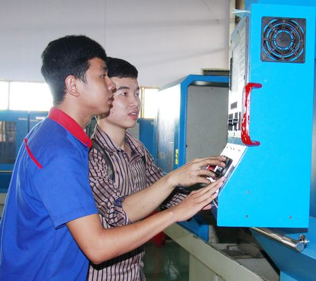 Sinh viên Nguyễn Thành Phát (áo sậm) bên máy CNC.