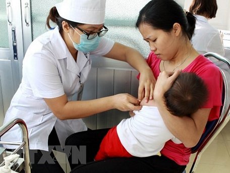Nhân viên y tế tiêm phòng cho trẻ tại Hà Nội. (Ảnh: TTXVN)