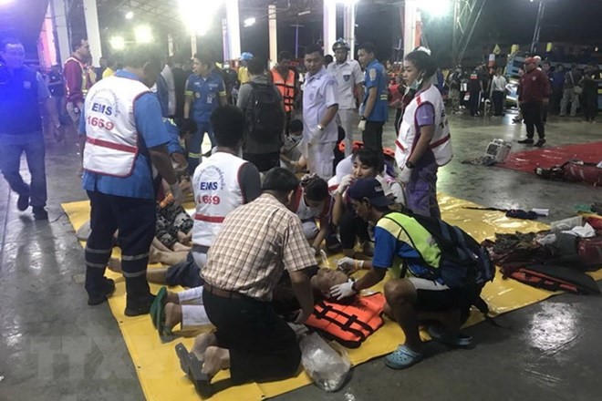 Nhân viên y tế sơ cứu cho nạn nhân được cứu sống trong vụ chìm tàu ở Phuket, Thái Lan ngày 5/7. (Ảnh: THX/TTXVN)