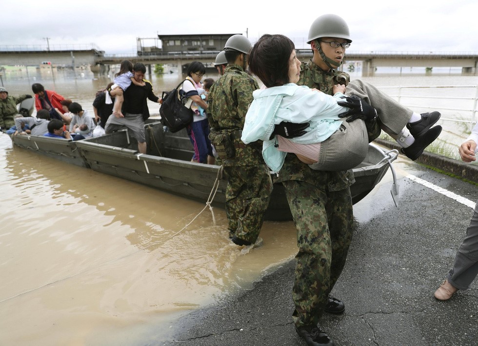 Lực lượng phòng vệ Nhật tham gia di tản người dân bị ảnh hưởng vì mưa lũ ở TP Kurashiki, phía nam Nhật, ngày 7/7 - Ảnh: REUTERS