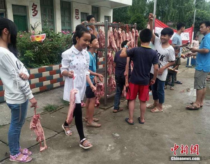 Mỗi em nhận được 1,5kg thịt heo - Ảnh: Chinanews