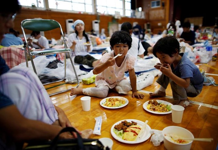 Cô bé Miyo Takeuchi, 7 tuổi, ăn cơm tại trung tâm sơ tán ở thị trấn Mabi, tỉnh Okayama. Ảnh: Reuters