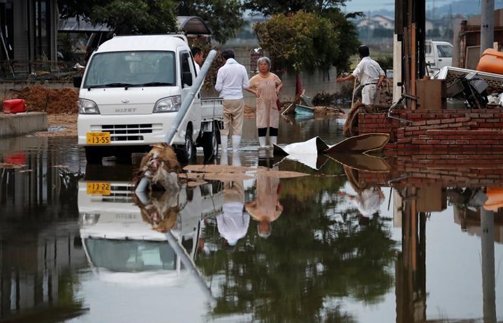 Người dân bàng hoàng trước sức tàn phá của trận mưa lũ. Ảnh: Reuters