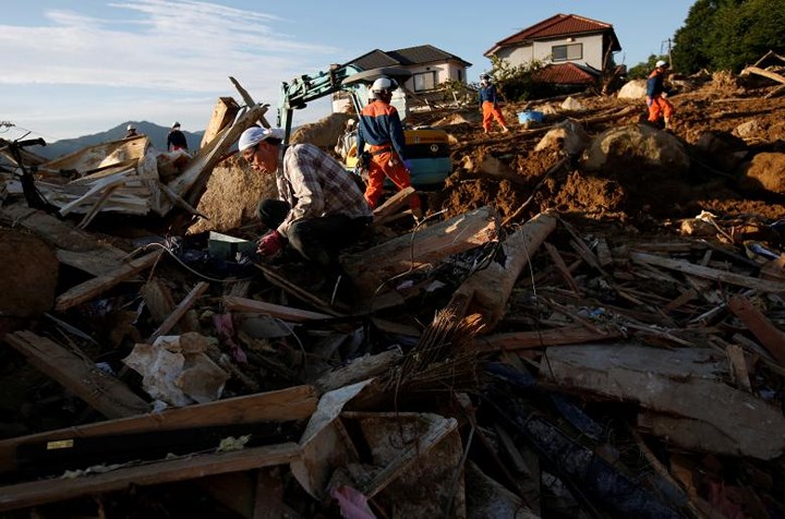Đống đổ nát của một ngôi nhà sau khi mưa lớn gây lở đất. Những người dân địa phương cũng tham gia nỗ lực tìm kiếm người thân đang bị chôn vùi vì lở đất. Ảnh: Reuters