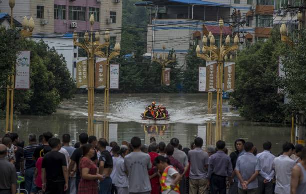 Tại nhiều tỉnh khác, các tuyến đường sắt, đường không và đường bộ cũng không thể tiếp tục vận hành. Trong ảnh là các nhân viên cứu hộ đưa vài người dân ra khỏi khu ngập nước ở tỉnh Chiết Giang.