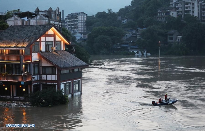 Mưa lớn và lũ lụt khiến nhiều khu vực như Vân Nam, Giang Tô và Thượng Hải hay thậm chí Trùng Khánh chìm trong biển nước. Trong ảnh là đội cứu hộ di chuyển trên một tuyến đường ngập trong nước ở thành phố Trùng Khánh, Tây Nam Trung Quốc.