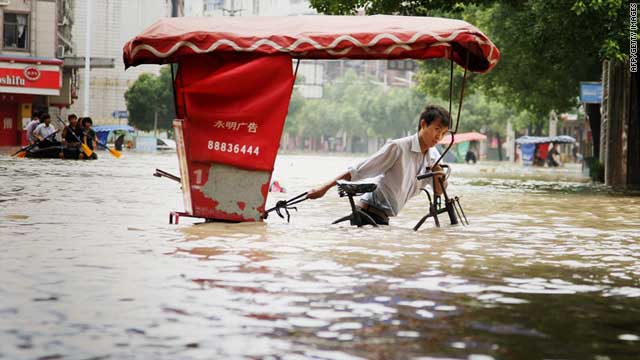 Một người đàn ông cố gắng kéo chiếc xe chở khách du lịch ra khỏi tuyến đường bị ngập nước. Theo Reuters, giới chức Trung Quốc cảnh báo rằng người dân không nên chủ quan bởi cả các địa điểm có địa hình cao như khu Nội mông cũng có nguy cơ bị ngập.