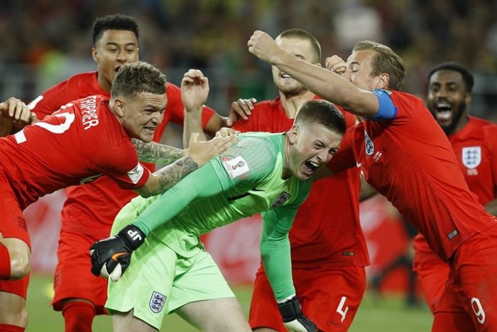 Thủ thành Jordan Pickford (Anh) bị các đồng đội vây chặt sau khi anh cản phá thành công cú sút luân lưu của ĐT Colombia đưa “Tam Sư” vào tứ kết World Cup 2018.