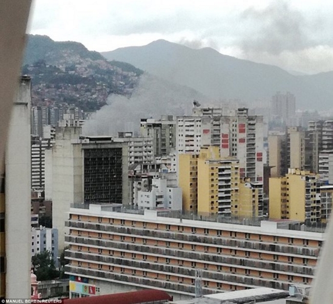 Khói xám bốc lên trên bầu trời thủ đô Caracas sau vụ nổ. Ảnh: Reuters.