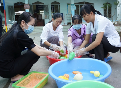 Giáo viên Trường Mầm non thị trấn Long Hồ dọn rửa đồ chơi cho bé bằng dung dịch Cloramin B.
