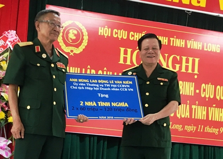 Dịp này, Anh hùng Lao động Lê Văn Kiểm (bên phải)- Chủ tịch Hiệp hội Doanh nhân Cựu chiến binh trao tặng biểu trưng 2 căn nhà nghĩa tình đồng đội cho hội.