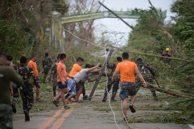Theo New York Times, sau 12 giờ bão Mangkhut đổ bộ vào Philippines, hiện đã có một trường hợp được ghi nhận là thiệt mạng. Giới chức Philippines vẫn chưa bắt đầu đánh giá thiệt hại do bão gây ra. Trong ảnh: Các nhân viên cứu hộ dựng lại các cây và cột điện bị đổ khi bão Mangkhut càn quét khu vực Baggao thuộc tỉnh Cagayan, phía bắc thủ đô Manila, Philippines sáng 15/9. (Ảnh: AFP)