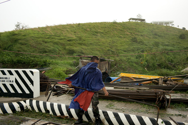 Bão Mangkhut được đánh giá là cơn bão mạnh nhất trong năm nay đổ bộ vào Philippines, ảnh hưởng tới khoảng 40 triệu người. Trong ảnh: Một sĩ quan cảnh sát dọn dẹp đống đổ nát do bão gây ra tại Philippines. (Ảnh: Bloomberg)