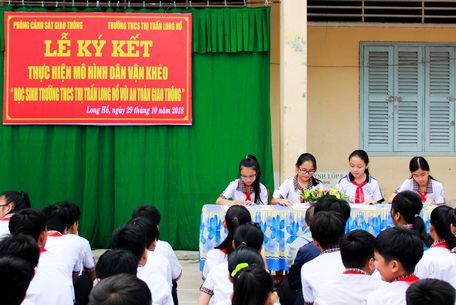 Các em học sinh Trường THPT chuyên Nguyễn Bỉnh Khiêm ký cam kết thực hiện an toàn giao thông.
