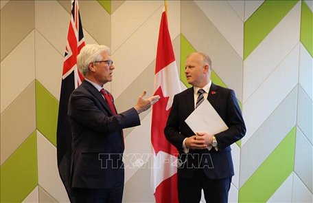 Bộ trưởng Đa dạng hóa thương mại quốc tế của Canada, ông Jim Carr (trái) trao quyết định phê chuẩn CPTPP của Canada cho ông Daniel Mellsop, Cao ủy New Zealand tại Canada. Ảnh: TTXVN