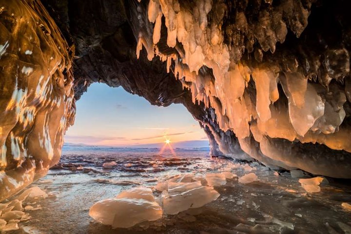 Hang động huyền bí nằm trên hòn đảo Olkhon, ở phía Đông Siberia với hàng trăm nhũ đá đóng băng vì thời tiết giá lạnh. Khi ánh nắng chiếu vào khiến chúng trở nên càng lung linh, rực rỡ hơn. Những tảng băng nằm lấp lửng dưới lớp tuyết cùng với ánh sáng mặt trời trông như những viên đá ngọc bích