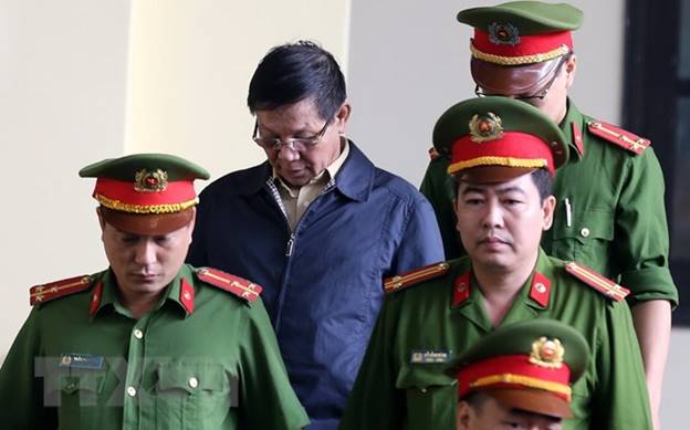  Lực lượng chức năng dẫn giải bị cáo Phan Văn Vĩnh vào tòa. (Ảnh: Trung Kiên/TTXVN)