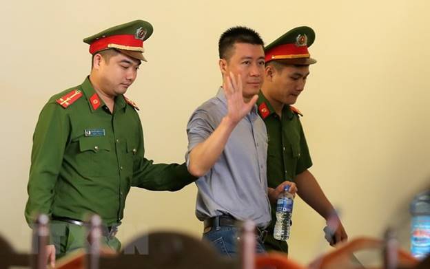  Lực lượng chức năng dẫn giải bị cáo Phan Sào Nam vào tòa. (Ảnh: Trung Kiên/TTXVN)