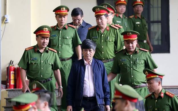  Lực lượng chức năng dẫn giải bị cáo Nguyễn Thanh Hóa vào phiên tòa. (Ảnh: Trung Kiên/TTXVN)